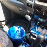 "Compact car storage bin in a vehicle hanging off a gear stick to keep vehicle neat and tidy"